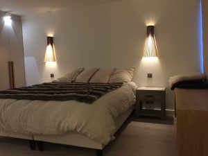 Chambre avec lit double et apliques en bois moderne