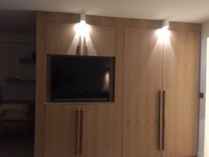 Mur de la chambre avec télé encastrée et spots blancs carrés