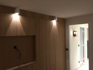 Mur de la chambre avec télévision encastrable et spots carrés blancs