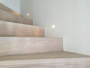Escaliers en bois montants avec spots encastrés au mur
