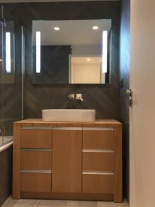 Salle-de-bains avec meuble en bois et carrelage gris en chevrons
